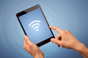 Female fingers touching tablet with wireless connection icon